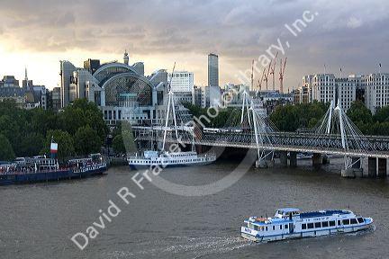 Charing Cross railway station at the north end of the Hungerford Bridge and Golden Jubilee Bridges crossing the River Thames in London, England.