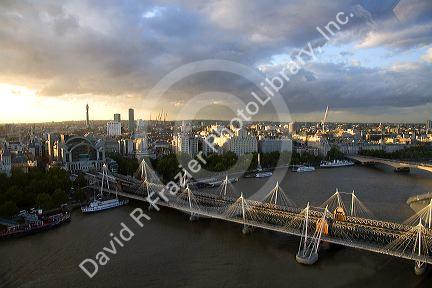 Charing Cross railway station at the north end of the Hungerford Bridge and Golden Jubilee Bridges crossing the River Thames in London, England.