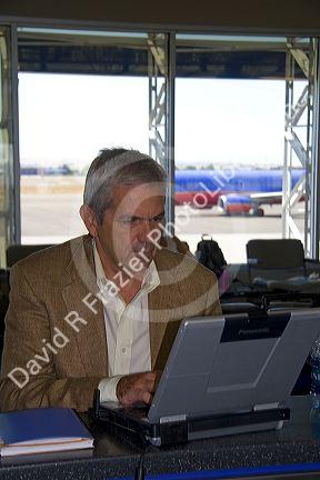 Man using a laptop computer in the Boise Airport, Boise, Idaho. MR