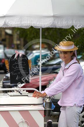 Female street vendor selling ice cream in the town of Moreton-in-Marsh, Gloucestershire, England.