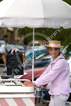 Female street vendor selling ice cream in the town of Moreton-in-Marsh, Gloucestershire, England.