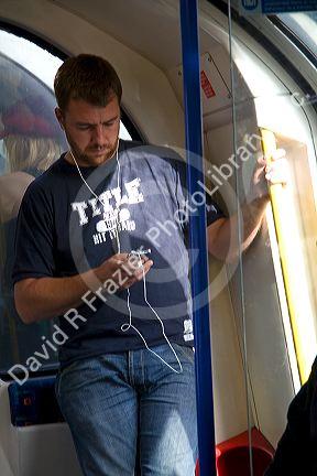 Man listening to an ipod on the London Underground metro system in London, England.