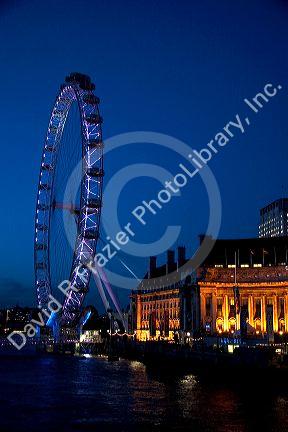 The London Eye at night along the River Thames in London, England.