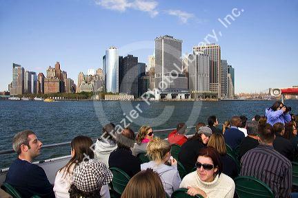 Passengers on a New York Harbor tour boat view Lower Manhattan, New York City, New York, USA.