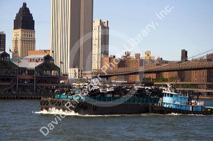 Tugboat guiding a garbage barge on the East River in New York City, New York, USA.