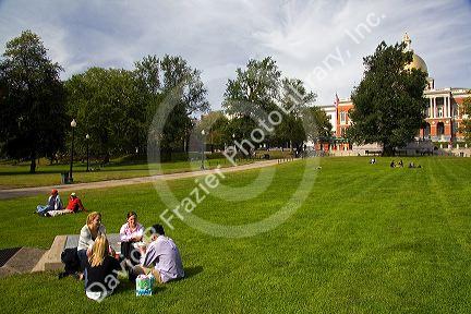 People socialize on Boston Common in front of the Massachusetts State House located in the Beacon Hill neighborhood of Boston, Massachusetts, USA.