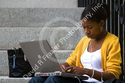 African American female student studying with a laptop on the campus of Harvard University in Cambridge, Greater Boston, Massachusetts, USA. MR