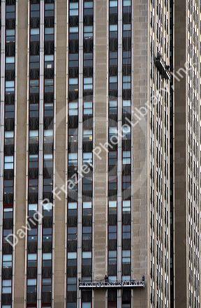 Window washers on a platform clean the windows of the Empire State Building in Manhattan, New York City, New York, USA.