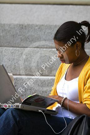 African American female student studying with a laptop on the campus of Harvard University in Cambridge, Greater Boston, Massachusetts, USA. MR