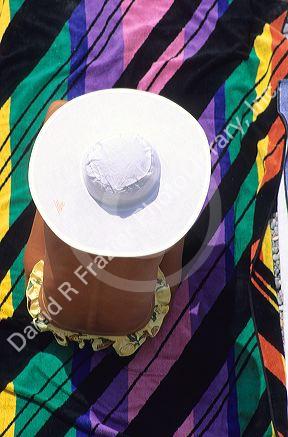 Woman wearing sun hat and sitting on a colorful towel in France.