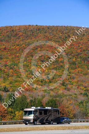 Motorhome traveling through fall foliage in the White Mountain National Forest, Grafton County, New Hampshire, USA.