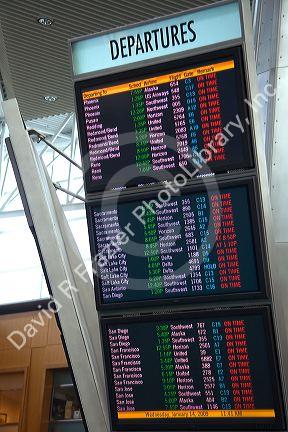 Airline departure notice board at the Portland International Airport in Portland, Oregon, USA.