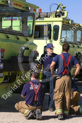 Firefighters taking direction from a training officer at an airport training facility in Boise, Idaho, USA.