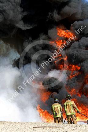 Firefighters using fire retardant foam to put out a jet fuel fire at an airport training facility in Boise, Idaho, USA.