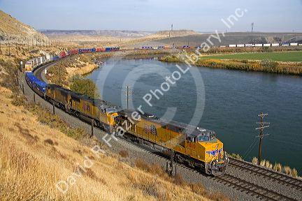 Union Pacific intermodal container train traveling along the Snake River in Elmore County, Idaho, USA.