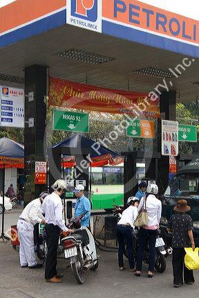 Vietnamese people fuel their motorbikes at a gas station in Ho Chi Minh City, Vietnam.