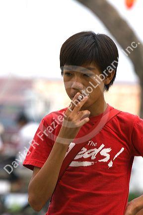 Young Vietnamese teen smoking a cigarette in Ho Chi Minh City, Vietnam.