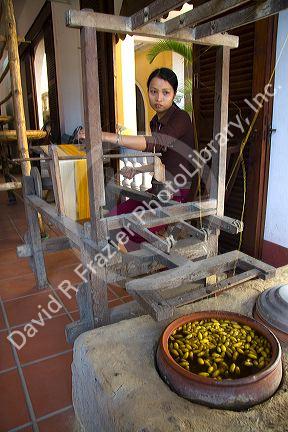 Vietnamese woman spinning silk from the silkworm cocoon in Hoi An, Vietnam.
