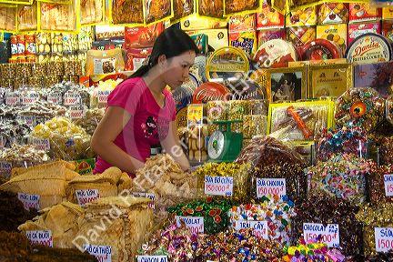 Female vendor selling treats in the Ben Thanh Market located in Ho Chi Minh City, Vietnam.