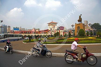 Vietnamese people ride motorbikes in front of the Ben Thanh Market in Ho Chi Minh City, Vietnam.