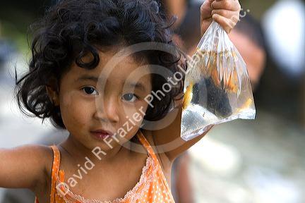 Vietnamese child holding a bag of pet fish caught in the Saigon River at Ho Chi Minh City, Vietnam.