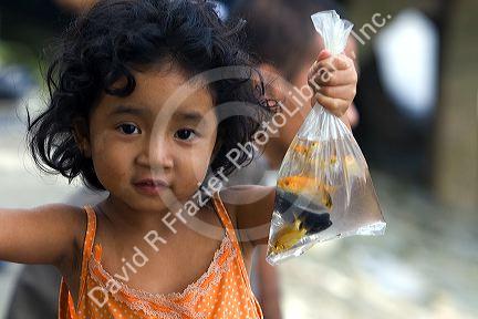 Vietnamese child holding a bag of pet fish caught in the Saigon River at Ho Chi Minh City, Vietnam.
