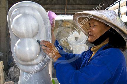 Vietnamese woman carving marble sculptures at a shop in Ngu Hanh Son ward south of Da Nang, Vietnam.