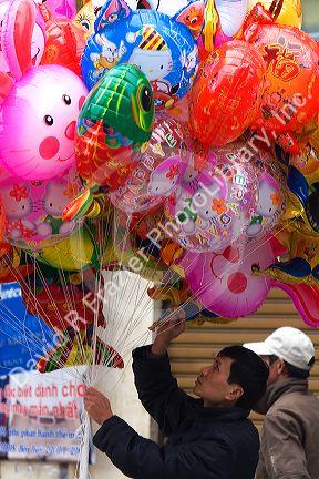 Street vendor selling colorful balloons for Tet in Hanoi, Vietnam.
