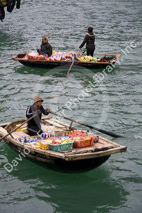 Vendors in boats selling snack food to tourists in Ha Long Bay, Vietnam.