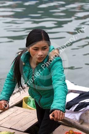 Vietnamese boat vendors selling fruit in Ha Long Bay, Vietnam.