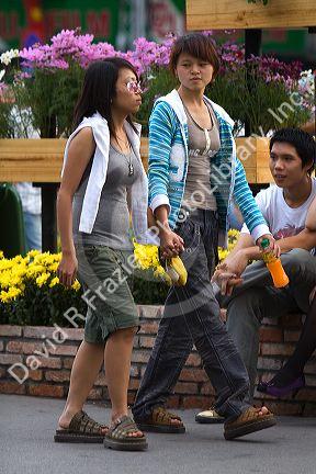 Vietnamese girls hold hands as a cultural jesture in Ho Chi Minh City, Vietnam.