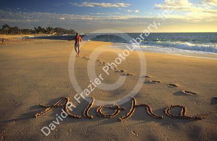 Aloha written in the sand on a Hawaiian beach.