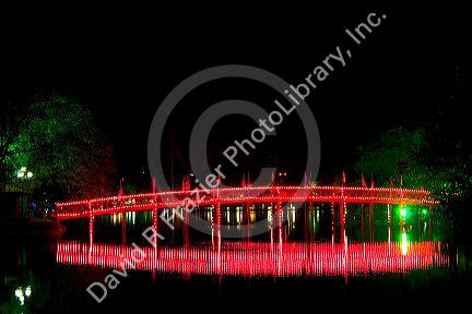 The Huc Bridge lit at night on Hoan Kiem Lake in Hanoi, Vietnam.