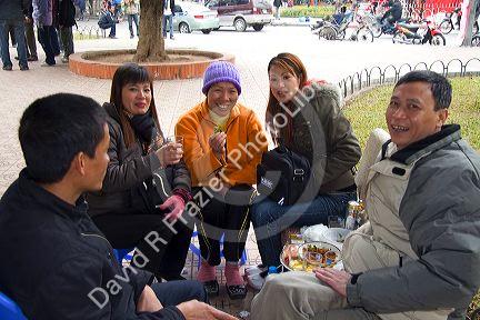 Vietnamese people socialize on the street during Tet festivities in Hanoi, Vietnam.
