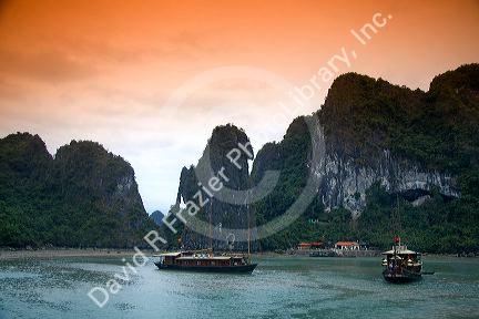 Scenic views of limestone karsts and tourist boats in Ha Long Bay, Vietnam.