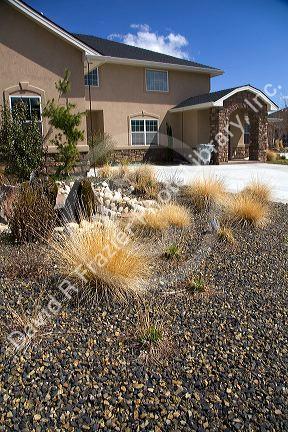 Xeriscaping using rock and native grass to conserve water at a residential home in Boise, Idaho, USA.