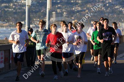 Teenagers jogging at Mission Beach in San Diego, Southern California, USA.
