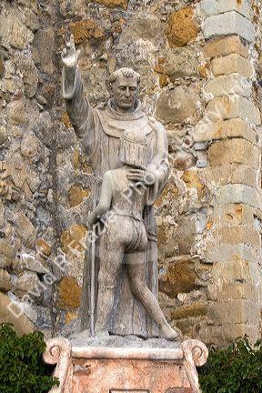 Statue in front of the Great Stone Church at Mission San Juan Capistrano, California, USA.