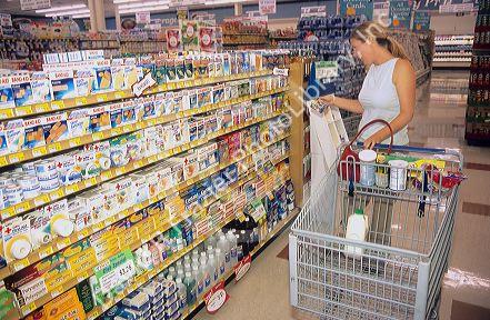 A woman shopping in the first aid section of a grocery store.