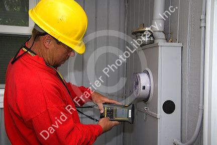 Idaho Power utility worker installing a new digital electric meter at a residential home in Boise, Idaho, USA.