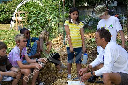 Students and teacher in a summer gardening class identify weeds from a residential garden in Boise, Idaho, USA.