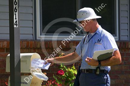 Postman delivering mail to a residence in Boise, Idaho, USA.