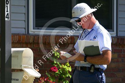 Postman delivering mail to a residence in Boise, Idaho, USA.