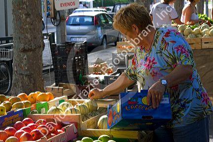 French vendor stocking produce at an outdoor market in Sanary sur Mer, Southern France.