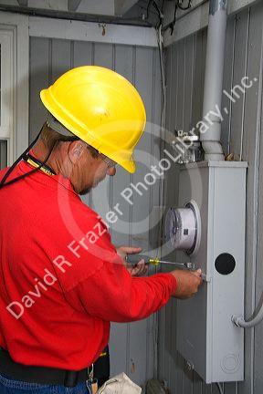 Idaho Power utility worker installing a new digital electric meter at a residential home in Boise, Idaho, USA.