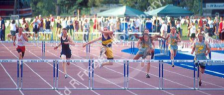 Male high school students racing in a hurdles track event. Boise, Idaho.
