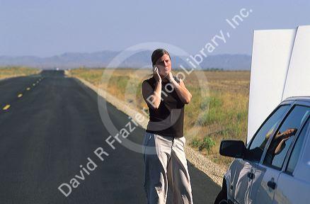 Stranded woman using a cell phone to call for help.