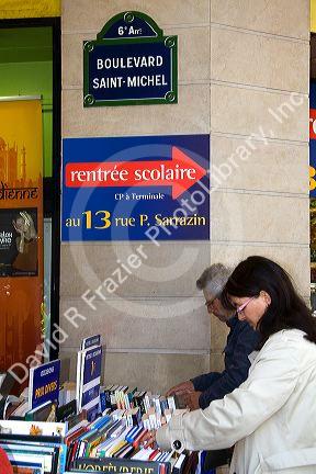 Customers shopping at a bookstore along Boulevard Saint-Michel in the Latin Quarter of Paris, France.
