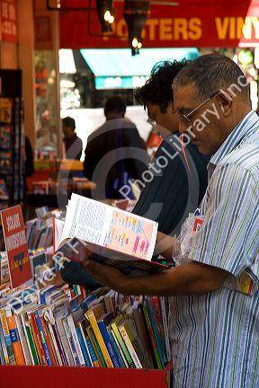 Customers shopping at a bookstore along Boulevard Saint-Michel in the Latin Quarter of Paris, France.