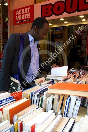 Customer shopping at a bookstore along Boulevard Saint-Michel in the Latin Quarter of Paris, France.